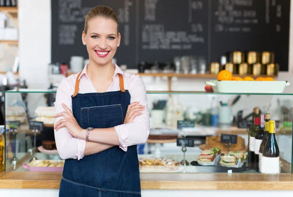 Femme avec un tablier représentant l'image de l'assurance commerce de la page assurances professionnelles.