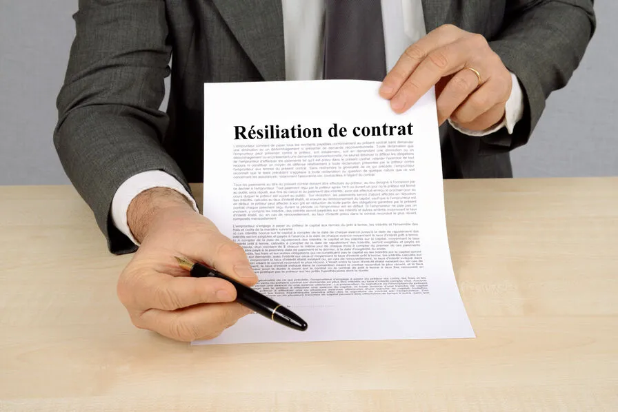 Un homme tenant un contrat de résiliation d'assurance prêt à faire signer son client.