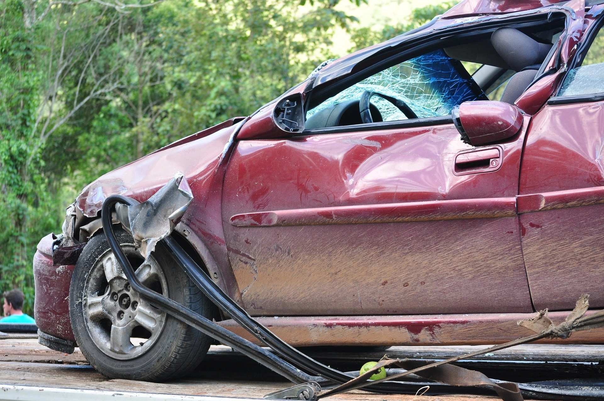 Une voiture accidentée, vitres brisées et avant enfoncé.